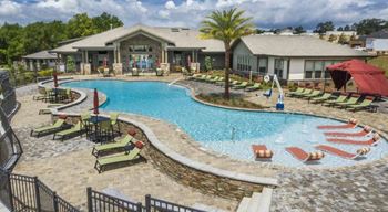 Resort-style swimming pool surrounded by lounge chairs and sundeck at The Retreat at Fairhope Village in Fairhope, AL